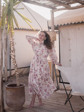 A lady wears a pink maxi dress.